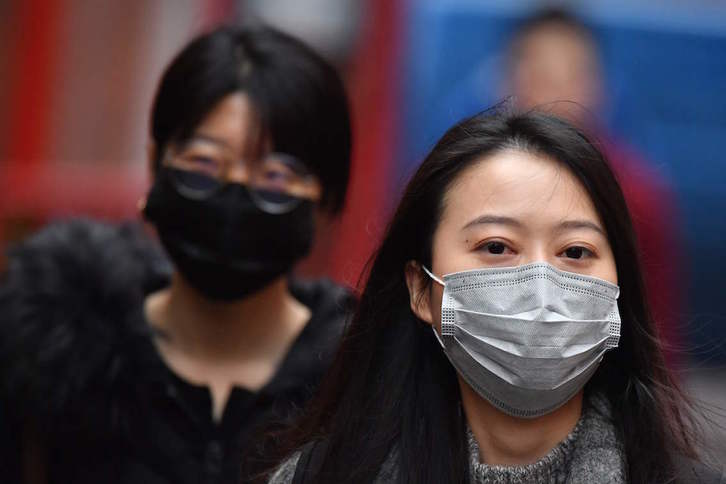 Dos jóvenes se protegen con mascarillas en el barrio Chinatown de Londres. (Ben STANSALL/AFP)
