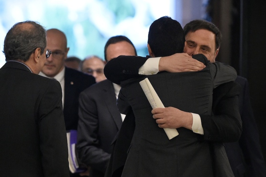 Junqueras se abraza con Torrent, president del Parlament, en presencia de Torra. (Josep LAGO | AFP)