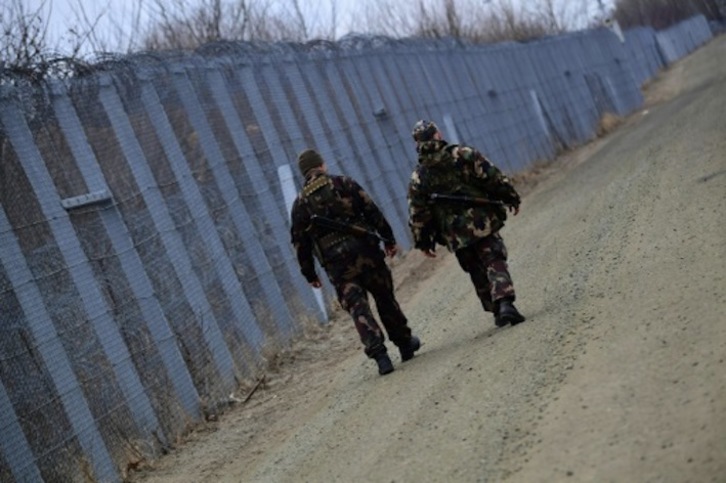 Imagen de archivo de dos guardias fronterizos patrullando cerca de la localidad húngara de Roszke, fronteriza con Serbia. (AFP)