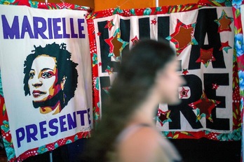 Una mujer camina junto a un cartel que recuerda a Marielle Franco en Río de Janeiro. (Daniel RAMALHO / AFP)