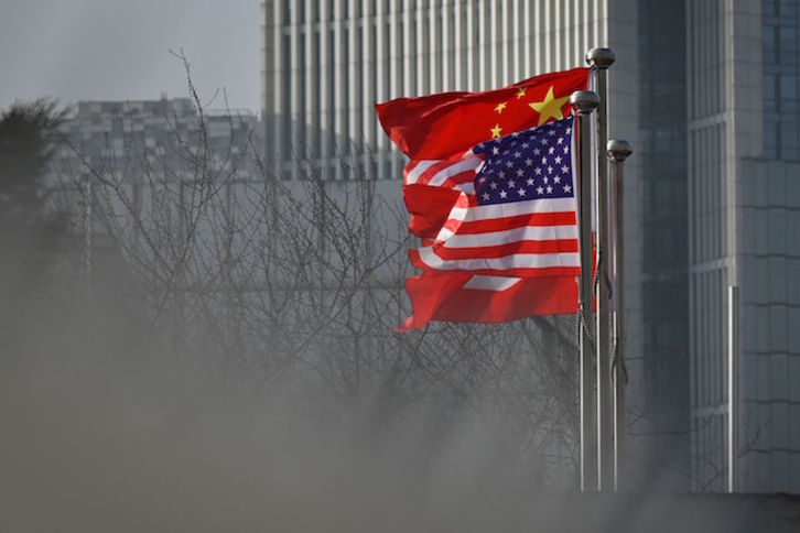 Las banderas de EEUU y China ondean en un edificio de oficinas en Pekín. (Wang ZHAO/AFP)