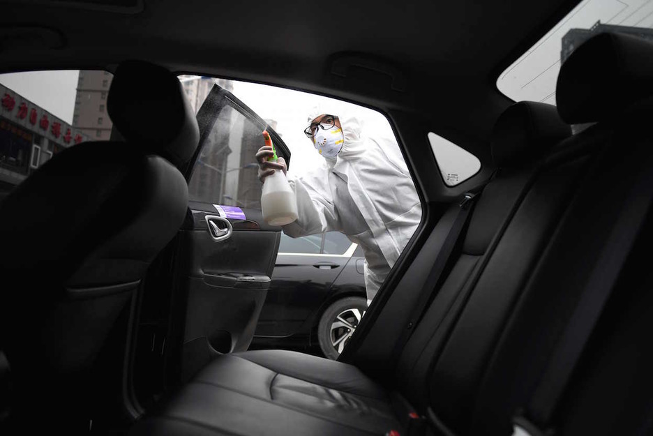 Un operario desinfecta un taxi en Pekín. (GREG BAKER / AFP)