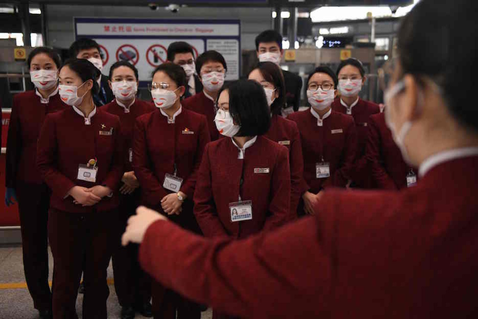 Personald e Air China, con mascarillas protectoras. (GREG BAKER / AFP) Personald e Air China, con mascarillas protectoras. (GREG BAKER / AFP)