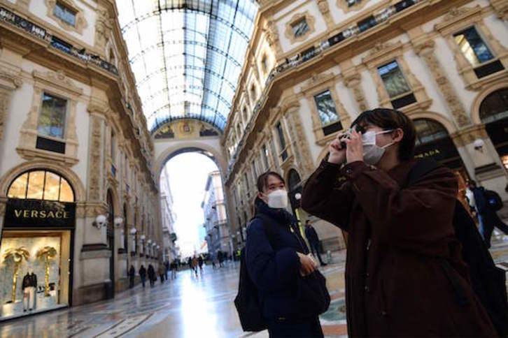 Turistas con mascarillas en el centro de Milán. (Miguel MEDINA/AFP)