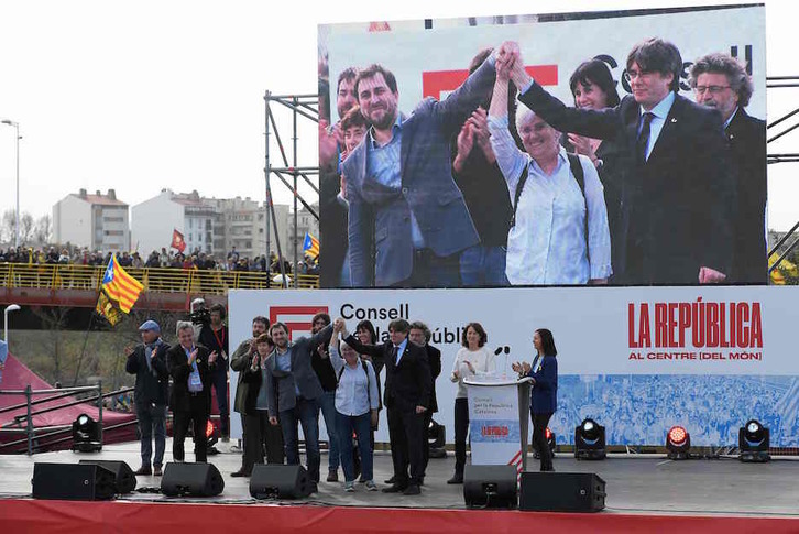 Líderes independentistas saludan desde el escenario. (Lluis GENÉ / AFP)