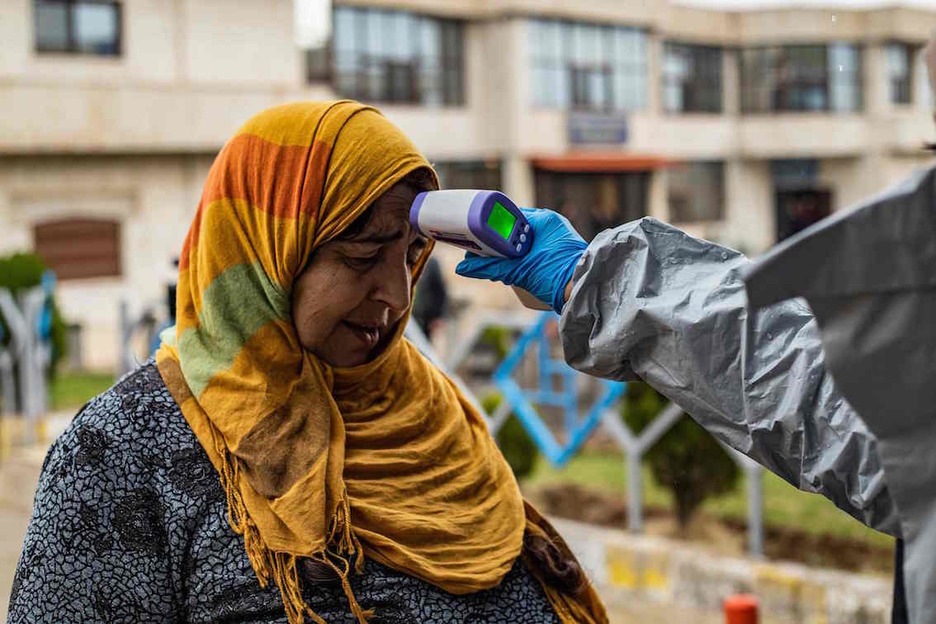 Un médico toma la temperatura a una mujer kurda en la frontera entre Siria e Irak. (Delil SOULEIMAN/AFP) Un médico toma la temperatura a una mujer kurda en la frontera entre Siria e Irak. (Delil SOULEIMAN/AFP)