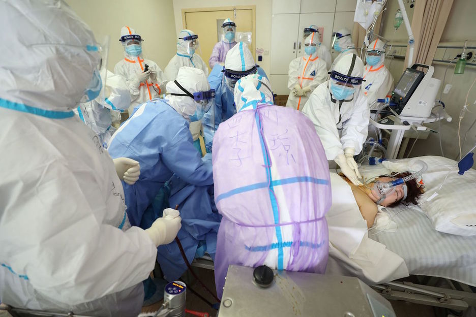Médicos atienden a un paciente infectado por Covid-19 en estado crítico en el hospital de Wuhan. (AFP)