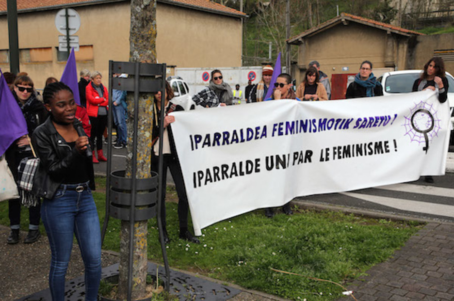 "Iparraldea feminismotik saretu" banderolaren ondoan, Clemence izeneko migranteak hartu zuen hitza. ©Bob EDME