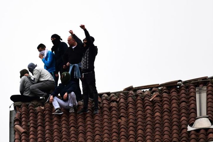 Presos en el tejado de la cárcel de Milán, la más grande de las sublevadas. (Miguel Medina/AFP)
