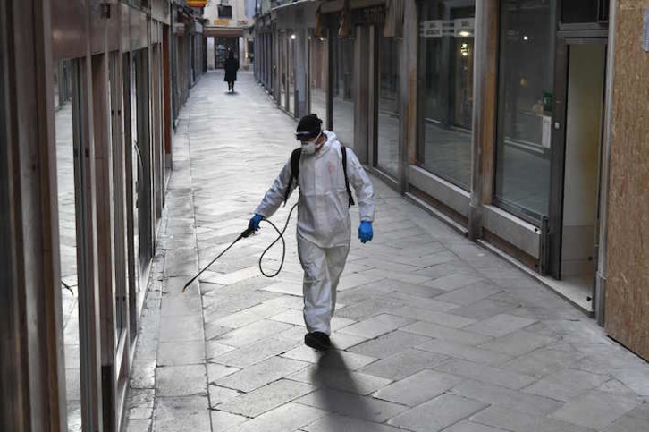 Un operario rocía las calles de Venecia con productos desinfectantes. (Marco SABADIN/AFP)