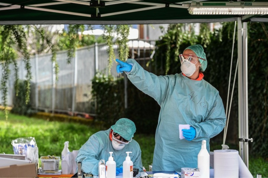 Trabajadores en la zona de recepción de la enfermería improvisada en Brescia. (Miguel MEDINA / AFP)