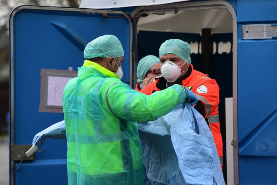 Trabajadores del hospital visten ropa de protección después de pasar por un proceso de limpieza. (Miguel MEDINA / AFP)
