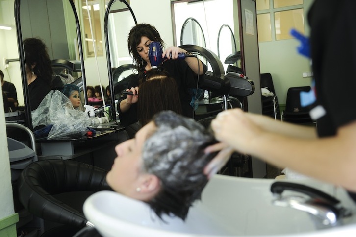 Alumna de una escuela de peluquería y moda practica distintos peinados. (Iñigo URIZ / FOKU)