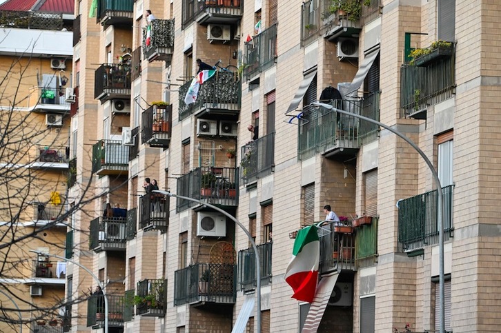 Desde los balcones, agitando banderas tricolores, mientras cantan «Una canzone per l'Italia» en el barrio Magliana de Roma. (Andreas SOLARO | AFP)