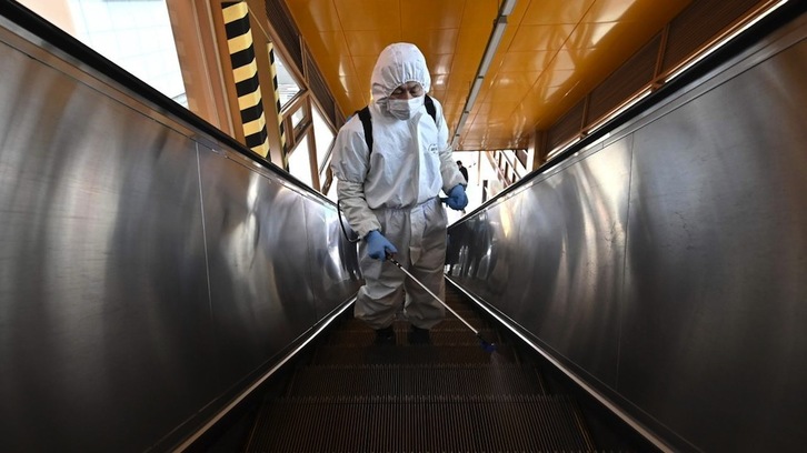 Operarios desinfectando las escaleras mecánicas del metro de Seúl. (AFP Photo)