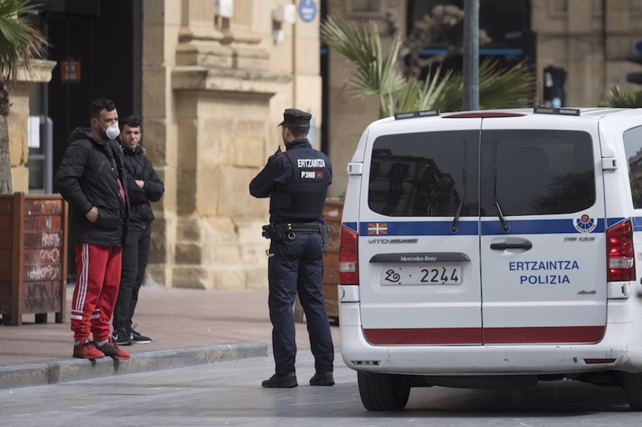 Un ertzaina pide explicaciones a dos viandantes en Donostia. (Juan Carlos RUIZ / FOKU)