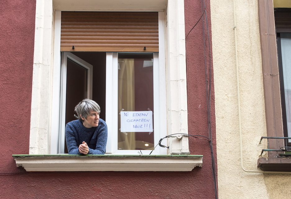 Una mujer se asoma a su ventana en Bilbo. (Marisol RAMÍREZ / FOKU)