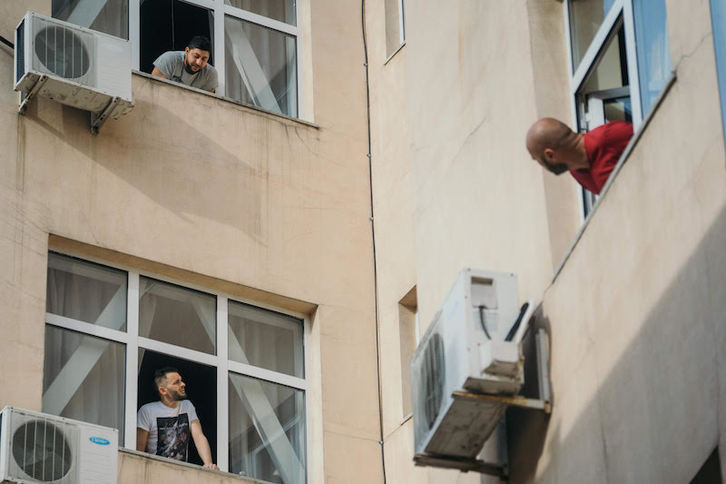 Personas confinadas, hablando de ventana a ventana en Rumanía. (Andrei PUNGOVSCHI | AFP)