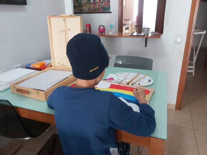 Un niño pinta en el salón de su casa. (SAVE THE CHILDREN)