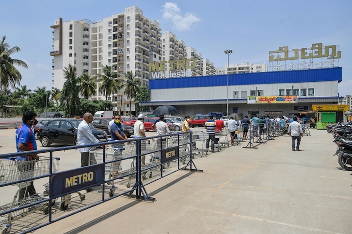 Gente esperando en la cola para entrar en un supermercado de la ciudad india de Bangalore. (Manjunath KIRAN/AFP)