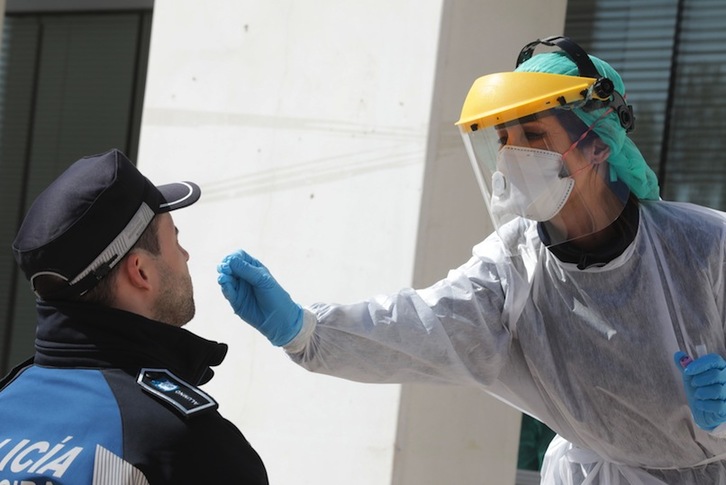 Una profesional sanitaria realiza el test a un agente de policía en Madrid. (Rafa ALBARRÁN/AFP)