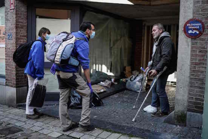 Atención a una persona sin hogar en Bruselas. (Kenzo TRIBOUILLARD / AFP)