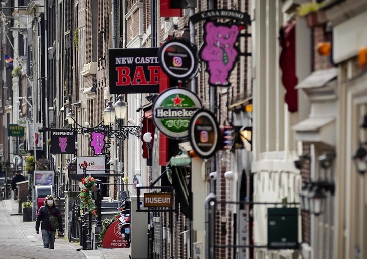 Un solitario paseante en el Barrio Rojo de Ámsterdam, cuyos burdeles están cerrados. (Robin VAN LONKHUIJSEN | AFP)