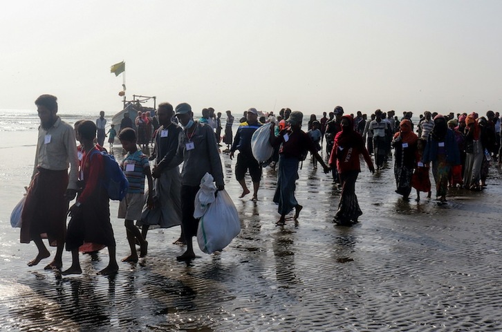 Refugiados rohingyás huyen cruzando un río de la persecución birmana. (STR)