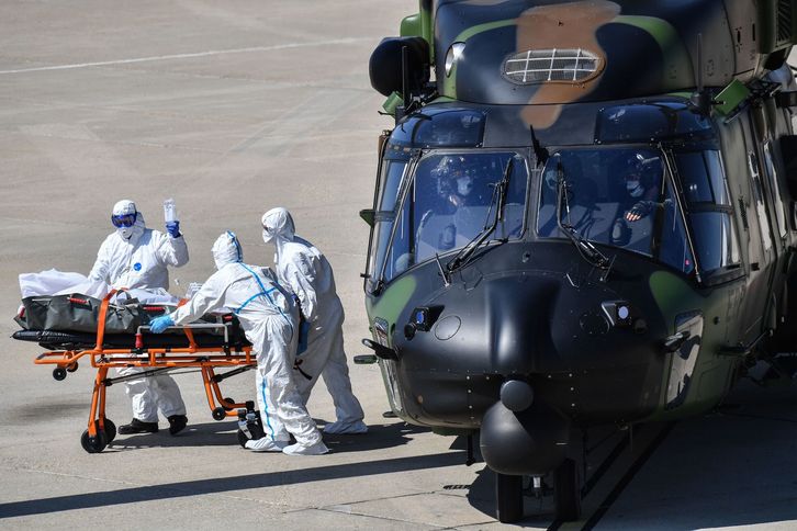 Sanitarios cargan a un paciente infectado en una ambulancia después de desembarcar de un helicóptero en la base aérea de Nimes, al sur del Estado francés. (Pascal GUYOT/AFP)