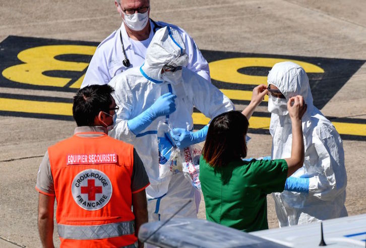 Servicios sanitarios se preparan para el traslado de contagiados. (Pascal GUYOT/AFP)