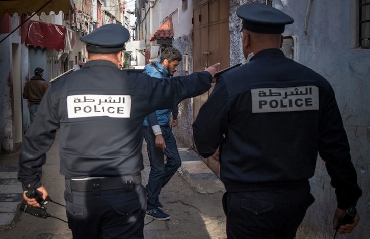 Policías marroquíes conminan a meterse en casa a los vecinos del barrio de Takadoum, en Rabat. (Fadel SENNA / AFP)
