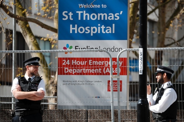 Dos policías aparecen en la entrada del hospital en el que se encuentra Boris Johnson. (Tolga AKMEN/AFP)