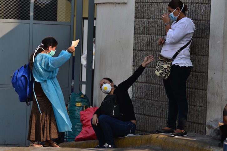 Varias mujeres hondureñas conversan a las puertas de la Escuela Universitaria Hospital de Tegucigalpa. (Orlando SIERRA/AFP)