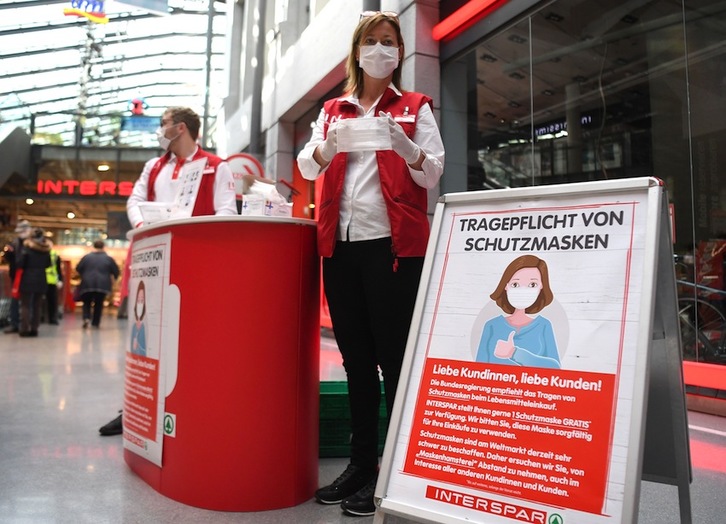 Trabajadoras de un supermercado de Viena reparten mascarillas a los clientes. (Helmut FOHRINGER | AFP)