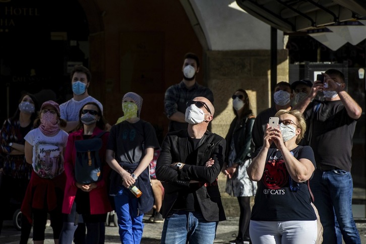 Gente enmascarada ante el Reloj Astronómico de Praga, con temor a contagiarse por el COVID-19. (Michal CIZEK / AFP PHOTO)