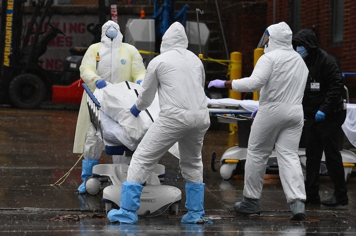 Personal médico en Nueva York traslada a uno de los más de 15.000 fallecidos que cuentan ya en Estados Unidos. (Angela WEISS / AFP PHOTO)