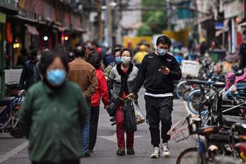 Ciudadanos en las calles de Wuhan. (Hector RETAMAL / AFP)