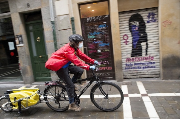 Una repartidora en bicicleta por las calles de Iruñea. (Iñigo URIZ/FOKU)