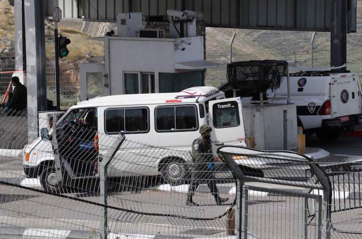 Un agente israelí pasa junto al vehículo que conducía el joven palestino. (Ahmad GHARABLI/AFP)