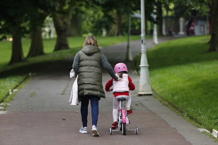 Una mujer y una niña en bici en el parque de Dona Casilda Iturrizar, en Bilbo. (Aritz LOIOLA | FOKU)