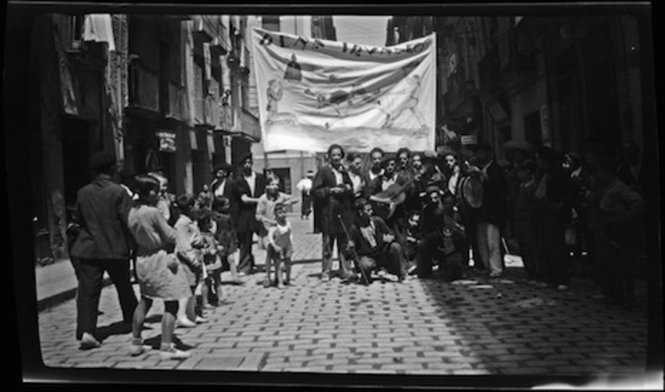 Los mozos de la peña Iruñako posan en la calle Estafeta. (José BELZUNCE GONZÁLEZ/ARCHIVO GENERAL DE NAFARROA)