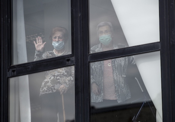 Usuarias de una residencia de Gasteiz saludan desde el interior de las instalaciones. (Raúl BOGAJO/FOKU)