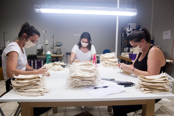 Le démaillage est une étape manuelle cruciale dans la confection de ces masques grand public en coton bio. © Guillaume FAUVEAU. 