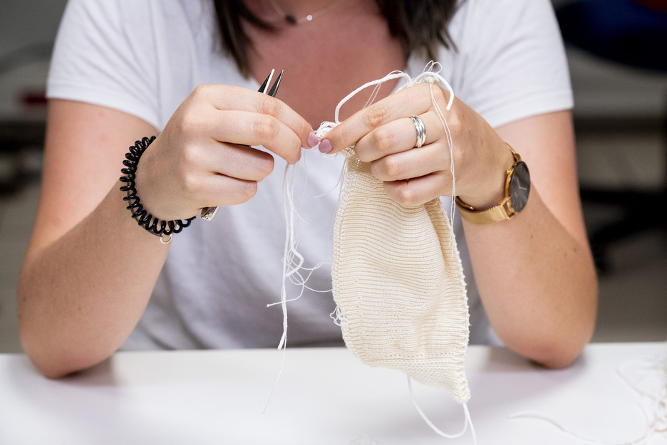 Le démaillage se fait manuellement, masque après masque. Une étape essentielle longue et fastidieuse. © Guillaume FAUVEAU.