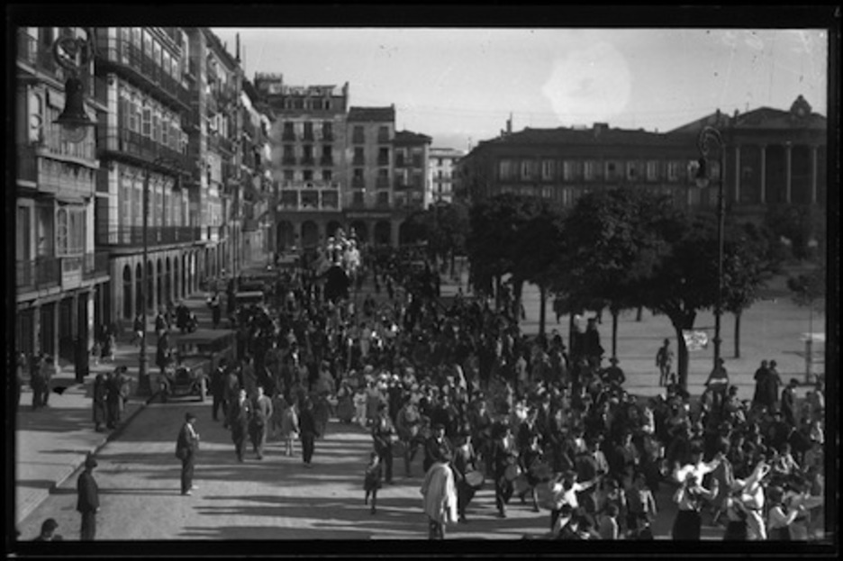 Desfile de dantzaris y txistularis acompañados por la Comparsa de Gigantes y Cabezudos de Iruñea a su paso por la plaza del Castillo. (GALLE/ARCHIVO GENERAL DE NAFARROA)