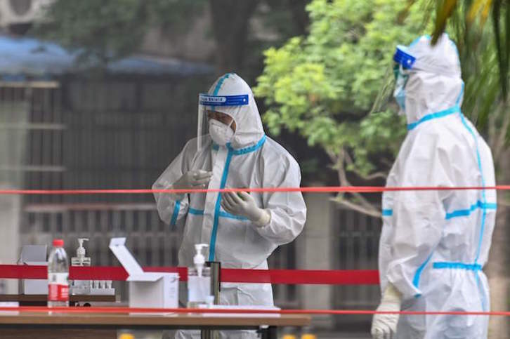 Dos sanitarios que realizan test en Wuhan a los once millones de habitantes. (Hector RETAMAL/AFP)