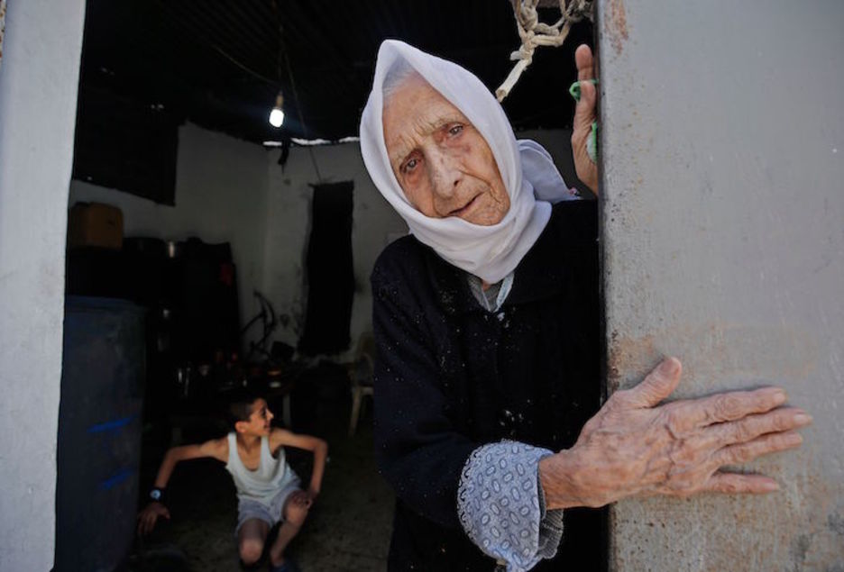 Una mujer que fue testigo directo de la Nakba, fotografiada a las puertas de su casa, en el campo de refugiados de Al-Shati, en Gaza. (Mohammed ABED/AFP)