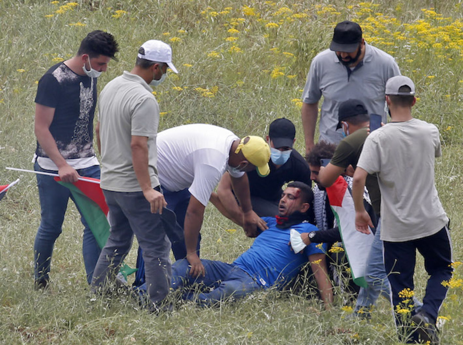 Palestinos atienden a un hombre herido por las fuerzas israelíes durante una protesta al sur de Nablus, en Cisjordania. (Jaafar ASHTIYEH/AFP)