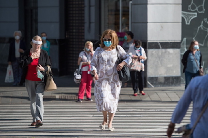 Personas caminando por Iruñea con mascarillas y pantallas protectoras puestas. (Iñigo URIZ/FOKU)