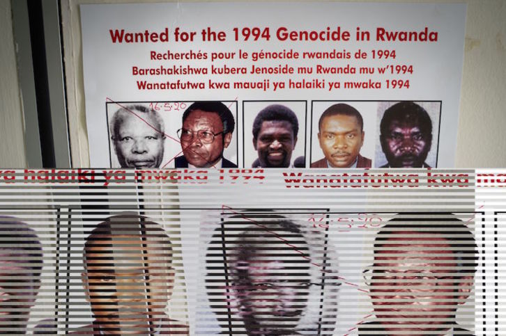 Cartel con los rostros de los más buscados por el genocidio de Ruanda, marcado tras el reciente arresto de Félicien Kabuga. (Simon WOHLFAHRT/AFP)